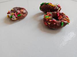 Close up of glazed doughnuts with bright colored sprinkles,isolated on a white background. photo