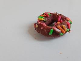 Close up of glazed doughnuts with bright colored sprinkles,isolated on a white background. photo