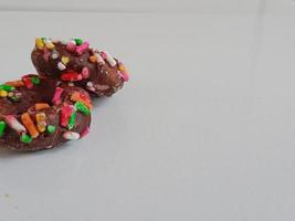 Close up of glazed doughnuts with bright colored sprinkles,isolated on a white background. photo