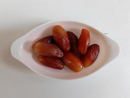 Pile of tasty dry dates isolated on white background. Arabic food photo