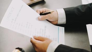 Justice and Law concept. Legal counsel presents to the client a signed contract with gavel and legal law or legal having team meeting at law firm in background video