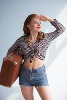 Retro pin-up girl with an old suitcase. photo