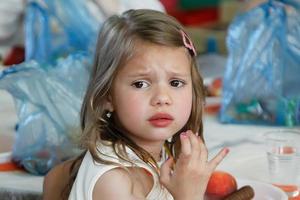 The child does not want to eat. Girl preschooler with sad eyes. photo