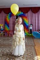 Girl preschooler with a balloon at the graduation party in kindergarten. photo