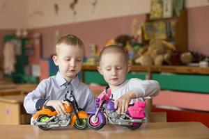 Children of elementary age play. Boy and girl from kindergarten with toy vehicles. photo