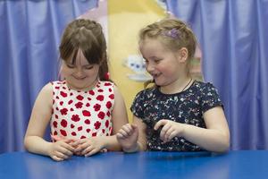 Belarus, the city of Gomil, April 26, 2019. Photoshoot in kindergarten. Two girls play at the table. photo