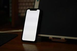 Photo of an empty cell phone with white screen on the table