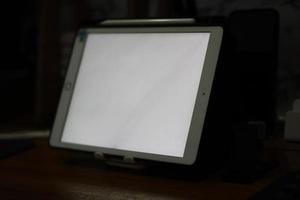 Photo of an empty tablet with white screen on the table