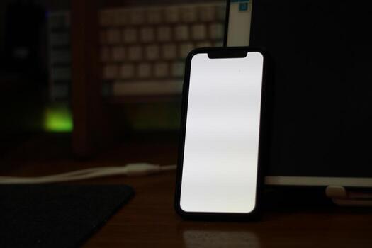 Photo of an empty cell phone with white screen on the table