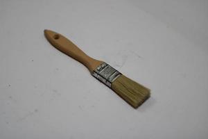 photo of a yellow brush made of wood with a white background