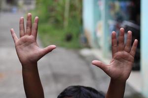 photo of hand waving outside the street