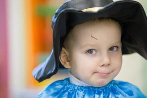 Portrait of a funny kid in the cap of a musketeer. photo