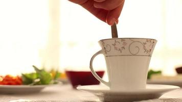 uma copo do chá em café da manhã tempo, mistura e bebendo uma copo do chá às café da manhã, vegetal café da manhã mesa, seletivo foco video