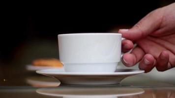 Person drink a cup of caffee in a cafe, relaxing with a cup of coffee, selective focus video