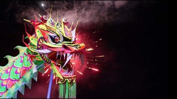 Select focus the dragon dance head with background of fireworks display video