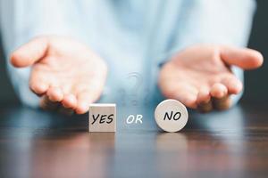 Concept of choice yes on wooden cubic blocks. Think with Yes or No choice, Business choices for difficult situations, Business woman hands with wooden with yes word on it. photo