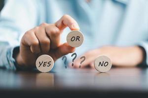 Concept of choice yes on wooden cubic blocks. Think with Yes or No choice, Business choices for difficult situations, Business woman hands with wooden with yes word on it. photo