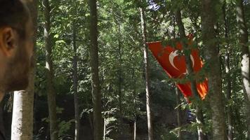 jung Mann suchen beim Türkisch Flagge im schleppend Bewegung. jung Türke suchen beim das winken Türkisch Flagge. video