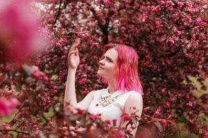 joven niña con rosado pelo en manzana huerta. foto