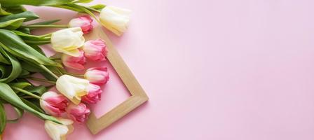 Pink Tulip flowers are arranged on a pink background. The view from the top, flat lay. Empty space for the text. Spring concept. Women's day. Mother's day. photo