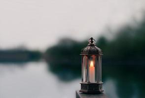 Ramadan Kareem, Arabic lantern with burning candle with blurry natural background.Image for Festive greeting card,invitation for Muslim holy month,Eid Mubarak,Eid al Adha,Eid al Fitr photo