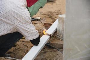 construction man is welding steel roof structure, people working in construction site concept photo