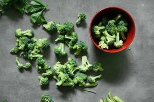 fresh broccoli strewn over concrete background photo