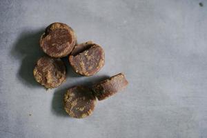 pile of brown sugar cubes on a concrete background photo