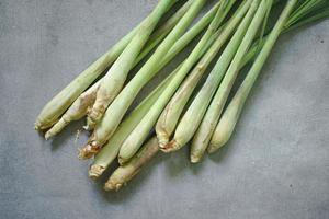 aromatic, freshly picked lemongrass leaves on concrete background photo