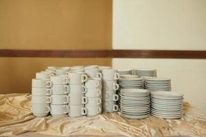 pile of cups and plates on the waiter's table photo