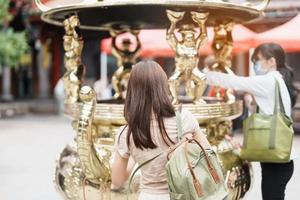 woman traveler visiting in Taiwan, Tourist with hat sightseeing in Longshan Temple, Chinese folk religious temple in Wanhua District, Taipei City. landmark and popular. Travel and Vacation concept photo