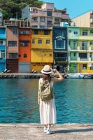 woman traveler visiting in Taiwan, Tourist with backpack and hat sightseeing in Keelung, Colorful Zhengbin Fishing Port, landmark and popular attractions near Taipei city . Asia Travel concept photo