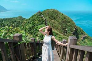 woman traveler visiting in Taiwan, Tourist with backpack sightseeing in Bitou Cape Hiking Trail, New Taipei City. landmark and popular attractions near Taipei. Asia Travel concept photo