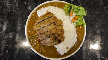 English chicken schnitzel curry with rice and good plating presentation. Thin slice of meat chicken breasts that is breaded and fried, popular dish in Germany. photo