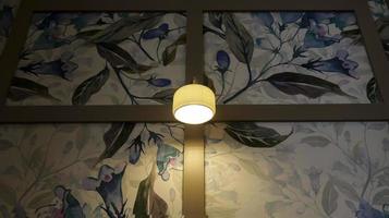 A simple minimalist wall lamp with a very beautiful artistic floral decoration background. photo