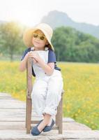 cute girl sit on wood chair with nature background photo