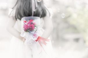 little bride holding the rose bouquet. photo