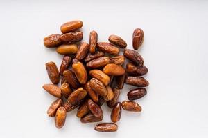 Dried dates fruit in wooden tray with soft napkin isolated on white background. photo