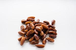 Dried dates fruit in wooden tray with soft napkin isolated on white background. photo