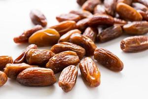 Dried dates fruit in wooden tray with soft napkin isolated on white background. photo