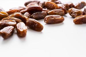 Dried dates fruit in wooden tray with soft napkin isolated on white background. photo