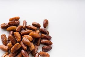 Dried dates fruit in wooden tray with soft napkin isolated on white background. photo