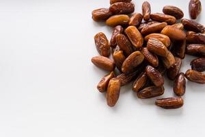 Dried dates fruit in wooden tray with soft napkin isolated on white background. photo