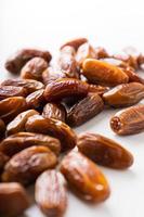 Dried dates fruit in wooden tray with soft napkin isolated on white background. photo