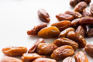 Dried dates fruit in wooden tray with soft napkin isolated on white background. photo