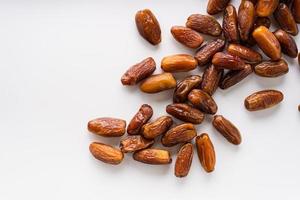 Dried dates fruit in wooden tray with soft napkin isolated on white background. photo