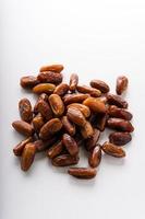 Dried dates fruit in wooden tray with soft napkin isolated on white background. photo