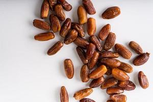 Dried dates fruit in wooden tray with soft napkin isolated on white background. photo