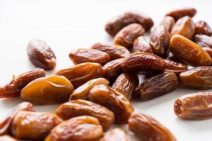 Dried dates fruit in wooden tray with soft napkin isolated on white background. photo