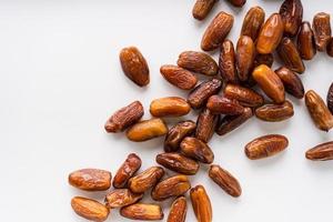 Dried dates fruit in wooden tray with soft napkin isolated on white background. photo